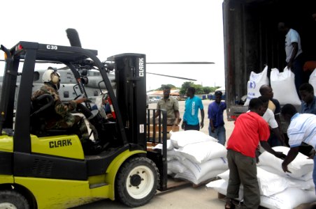 US Navy 080908-N-3595W-019 Port-au-Prince residents help U.S. service members assigned to the amphibious assault ship USS Kearsarge (LHD 3) prepare relief supplies for distribution to hurricane victims