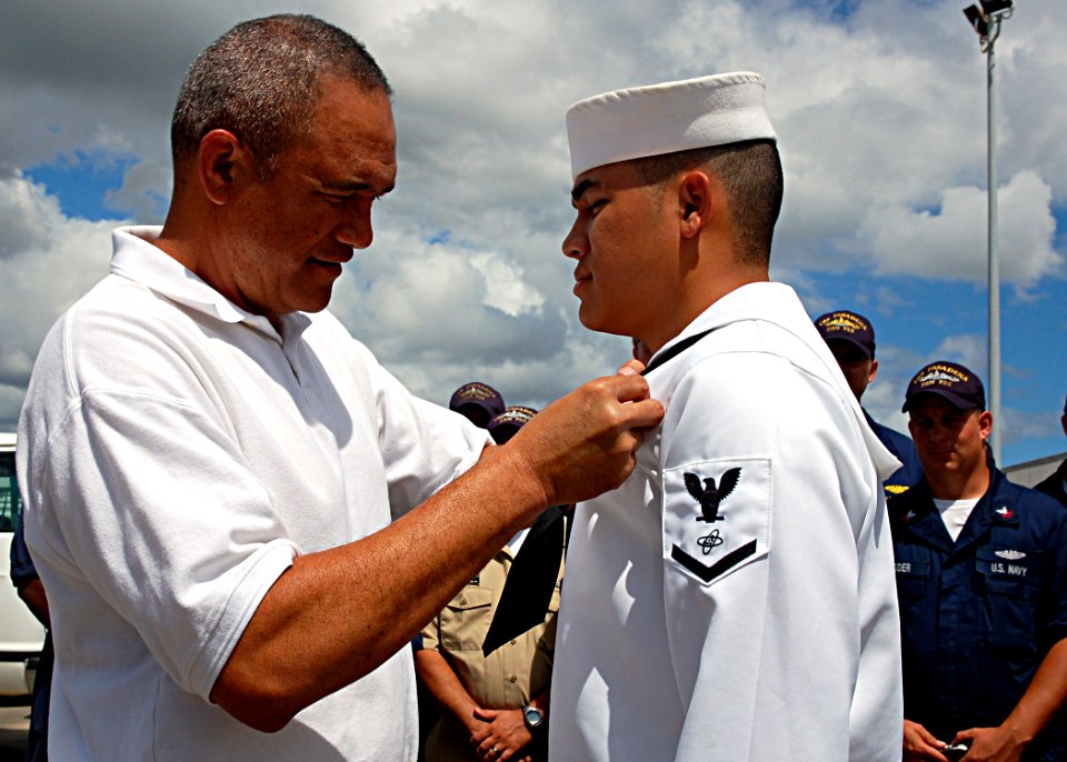 US Navy 080905-N-9486C-001 Retired Machinist Mate Senior Chief Henry Kanahele, a plank owner of the fast-attack submarine USS Los Angeles (SSN 688), pins the Submarine Warfare breast insignia on his son