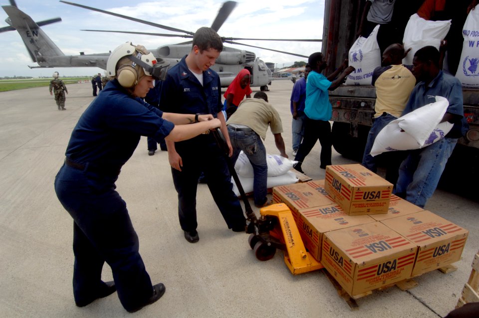 US Navy 080909-N-3595W-226 Locals from Port-au-Prince, Haiti work with U.S. Navy personnel assigned to the amphibious assault ship USS Kearsarge (LHD 3) to unload food and water for delivery to citizens affected by the recent h