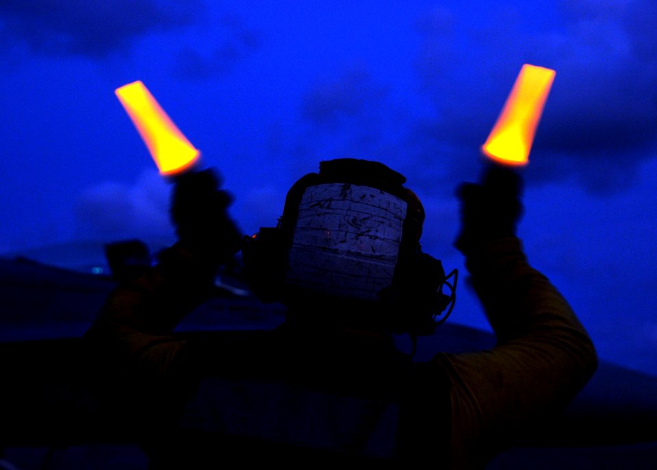 US Navy 080906-N-9898L-364 An aviation boatswain's mate handler from the aircraft carrier USS Abraham Lincoln's (CVN 72) Air Department directs an F-A-18C hornet assigned to the