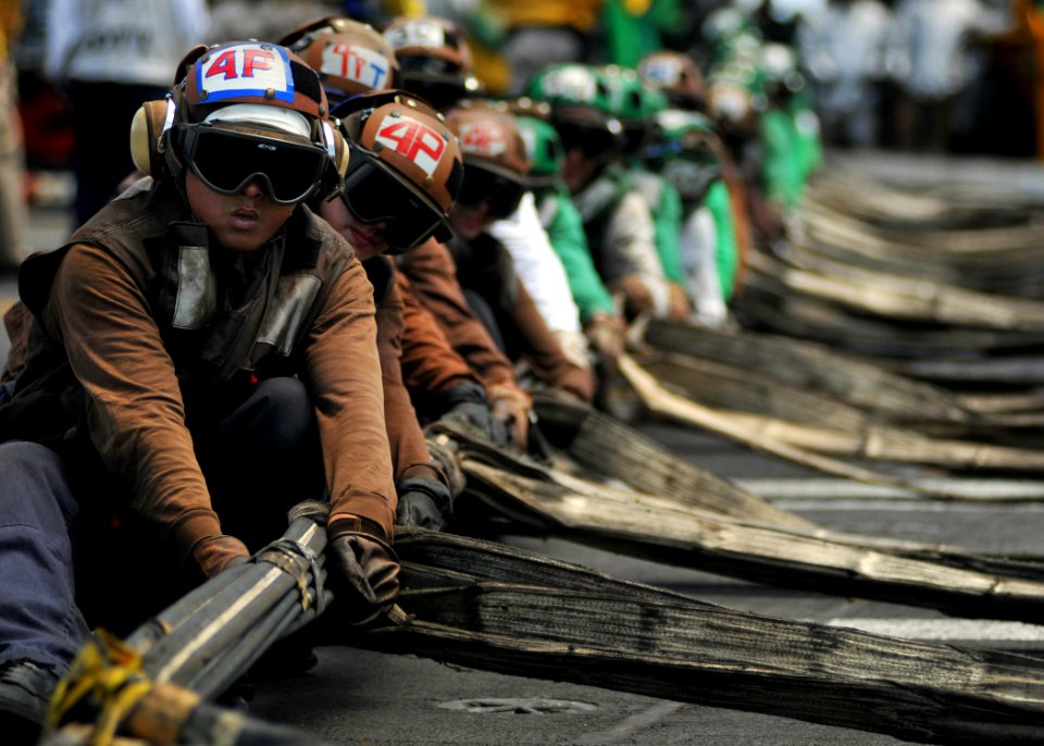 US Navy 080904-N-7981E-109 Flight deck personnel line rig barricades during a drill aboard the Nimitz-class aircraft carrier USS Abraham Lincoln (CVN 72) photo