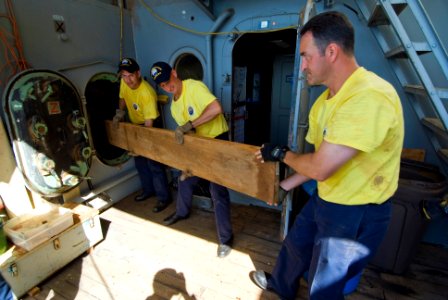 US Navy 080903-N-6674H-001 Hawaii region chief petty officer (CPO) selectees, part of the USS Missouri CPO legacy Academy class 002, pass teak wood inside the USS Missouri Memorial for storage during a service project on the hi