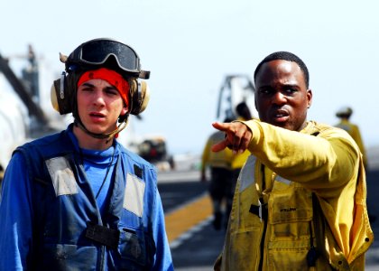 US Navy 080905-N-2183K-004 Crew members discuss how to fight a simulated fire during a flight deck fire drill aboard the amphibious assault ship USS Peleliu (LHA 5)