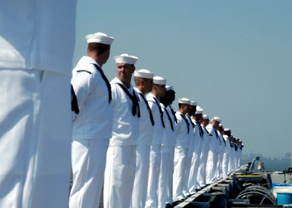 US Navy 080908-N-7239B-003 Sailors man the rails as the aircraft carrier USS Theodore Roosevelt (CVN 71) is escorted out to sea after leaving Naval Station Norfolk