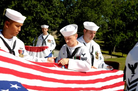 US Navy 080908-N-8467N-001 Electronics Technician (Chief Select) Chase Smith, assigned to Naval Submarine School at Naval Base New London, Conn. cuts off the first strip of the American flag in a flag retirement ceremony photo