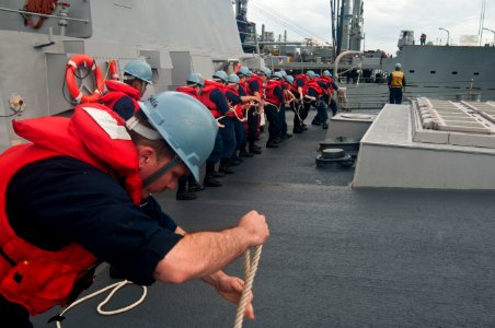 US Navy 111107-N-EA192-025 Sailors assigned to the guided-missile destroyer USS Mustin (DDG 89) heave a line during a replenishment at sea photo