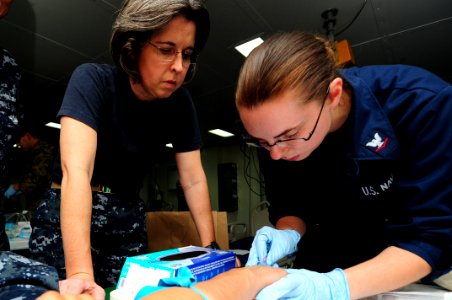 US Navy 111001-N-WA347-352 Lt. Cmdr. Nancy Powell, left, an anesthesiologist assigned to Fleet Surgical Team 7, trains Hospital Corpsman 3rd Class