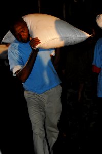 US Navy 080909-N-3595W-515 A Haitian man carries a sack of rice at a staging area in Port-au-Prince, Haiti
