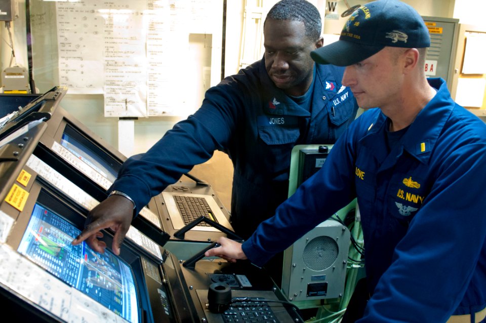 US Navy 110909-N-PB383-469 Engineman 1st Class Kevin Jones explains the capabilities of the command and control center to Ensign Patrick Love a