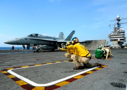 US Navy 080909-N-7241L-006 Flight deck personnel aboard the aircraft carrier USS Theodore Roosevelt (CVN 71) prepare to launch an F-A-18 strike fighter