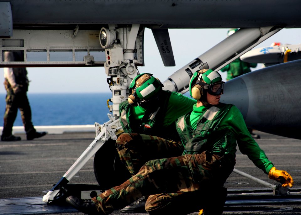 US Navy 080909-N-7241L-007 Flight deck personnel aboard the aircraft carrier USS Theodore Roosevelt (CVN 71) prepare to launch an F-A-18 strike fighter