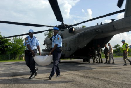 US Navy 080910-N-3595W-463 Haitian National Police work with joint military personnel embarked aboard the amphibious assault ship USS Kearsarge (LHD 3) to prepare food and water supplies for distribution photo