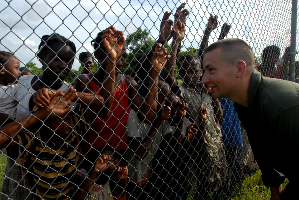 US Navy 080910-N-3595W-505 Capt. Jeff Hullinger, assigned to Marine Heavy Helicopter Squadron (HMH) 464 embarked aboard the amphibious assault ship USS Kearsarge (LHD 3), speaks to Haitian children photo