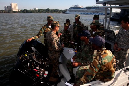 US Navy 111111-A-IP644-144 Cpl. Luis Castillo works with a Dominican sailor on small boat maintenance photo