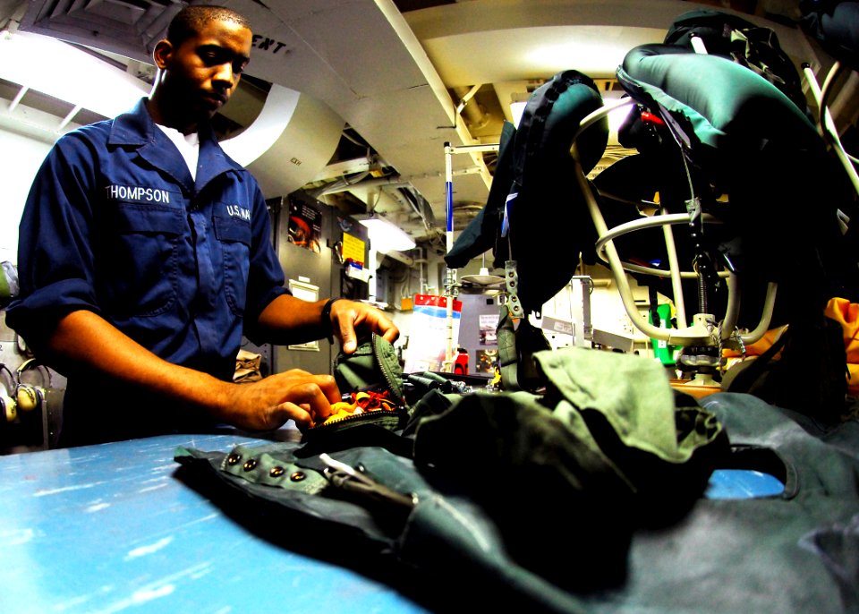 US Navy 080912-N-2183K-109 Aircrew Survival Equipmentman Airman Marquise Thompson inspects flotation devices aboard the amphibious assault ship USS Peleliu (LHA 5)