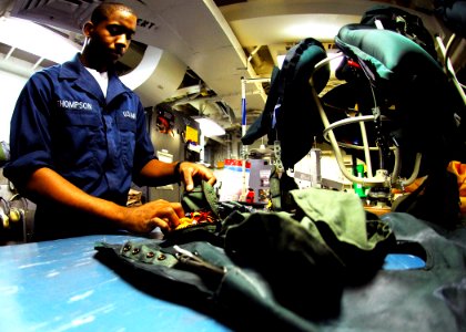 US Navy 080912-N-2183K-109 Aircrew Survival Equipmentman Airman Marquise Thompson inspects flotation devices aboard the amphibious assault ship USS Peleliu (LHA 5)