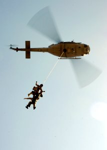 US Navy 080910-N-5366K-140 Helicopter Rope Suspension Training (HRST) students hang beneath a UH-1 Huey helicopter as they perform a Special Patrol Insertion-Extraction (SPIE) exercise during the HRST course at Naval Special Wa