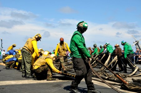 US Navy 111022-N-VD490-005 Air department Sailors pull out the barricade webbing assembly during flight deck drills aboard the aircraft carrier USS