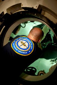 US Navy 111103-N-JN664-006 Chief Navy Diver Cory Hall prepares hoses for dewatering inside a sealed chamber