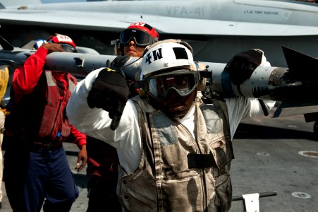US Navy 110729-N-BT887-039 Aviation Ordnanceman 1st Class Theo Hill directs the transfer of ordnance aboard USS John C. Stennis (CVN 74)