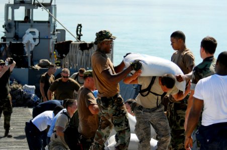 US Navy 080912-N-4515N-733 Service members embarked aboard the amphibious assault ship USS Kearsarge (LHD 3) unload food and supplies for delivery to areas affected by recent hurricanes photo