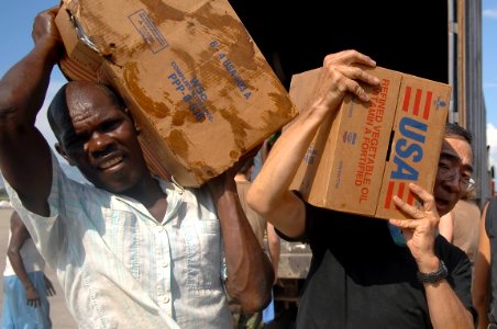 US Navy 080912-N-1508S-104 Service members embarked aboard the amphibious assault ship USS Kearsarge (LHD 3), and Hatian volunteers unload food and supplies for delivery to areas affected by recent hurricanes photo