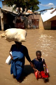 US Navy 080915-N-1508S-238 A Haitian woman leads her child through the streets of Gonaives, an area of Haiti devastated by recent hurricanes
