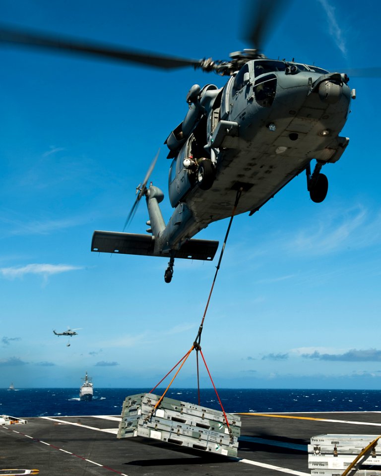 US Navy 110807-N-BT887-626 An MH-60S Sea Hawk helicopter lowers cargo onto the deck of USS John C. Stennis (CVN 74)