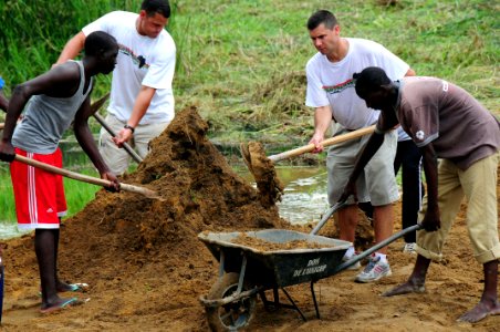 US Navy 080912-N-7526R-300 Lt. Argus Cunningham and Cmdr. Steve Hargatai help move dirt to fill in a flooded courtyard