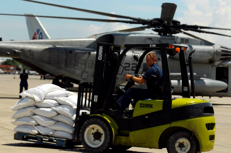 US Navy 080913-N-4515N-035 Service members embarked aboard the amphibious assault ship USS Kearsarge (LHD 3) load supplies onto helicopters for delivery to areas affected by recent hurricanes in Haiti