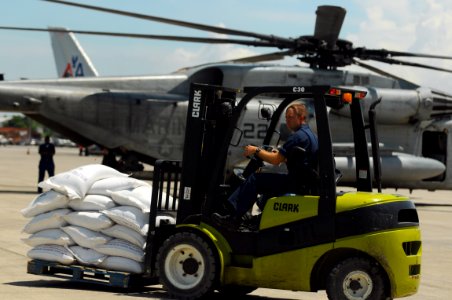 US Navy 080913-N-4515N-035 Service members embarked aboard the amphibious assault ship USS Kearsarge (LHD 3) load supplies onto helicopters for delivery to areas affected by recent hurricanes in Haiti photo