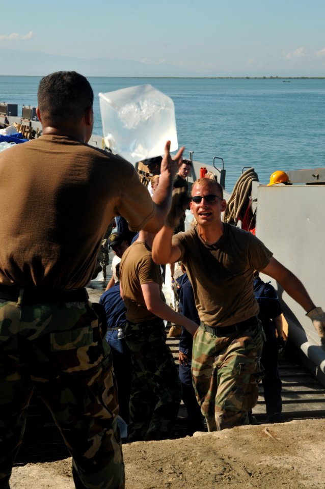US Navy 080915-N-8907D-348 Service members embarked aboard the amphibious assault ship USS Kearsarge (LHD 3) unload jugs of drinking water during a humanitarian assistance mission in Haiti