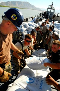 US Navy 080912-N-4515N-023 Service members embarked aboard the amphibious assault ship USS Kearsarge (LHD 3) unload food and supplies for delivery to areas affected by recent hurricanes photo