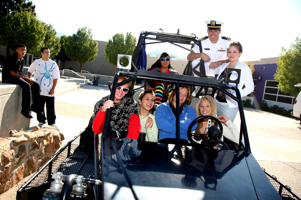 US Navy 080917-N-3271W-011 Lt. Andrew Baldwin, M.D. stands atop the Desert Patrol Vehicle with students from Monzano High School