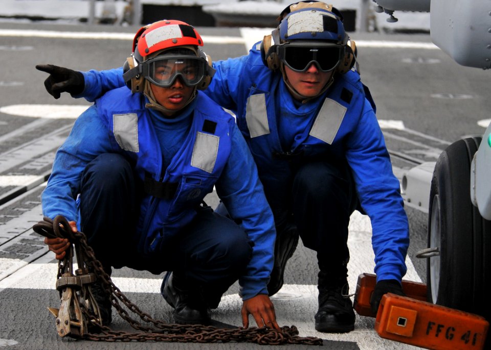 US Navy 110625-N-PB383-510 Boatswain's Mate Seaman Evandare Aganon, left, and Operations Specialist 3rd Class John Walter remove the chock and chai