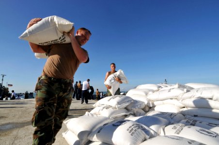 US Navy 080915-N-8907D-051 Hospital Corpsman Shane Leidig, embarked aboard the amphibious assault ship USS Kearsarge (LHD 3), carries a sack of rice during a humanitarian assistance mission in Haiti
