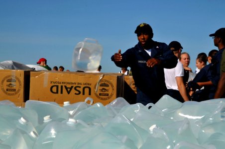 US Navy 080915-N-8907D-140 Boatswain's Mate 3rd Class LeRon Spencer, embarked aboard the amphibious assault ship USS Kearsarge (LHD 3), carries a sack of rice during a humanitarian assistance mission in Haiti photo