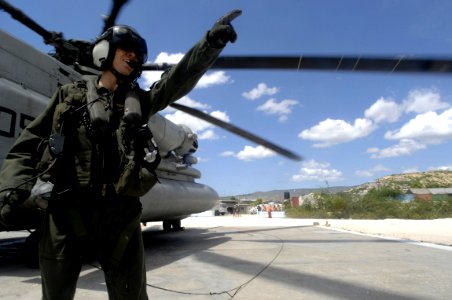 US Navy 080915-N-9620B-688 Lance Cpl. Clarence Carr, assigned to Marine Heavy Helicopter Squadron (HMH) 464 embarked aboard the amphibious assault ship USS Kearsarge (LHD 3), gives direction to Haitian relief workers unloading