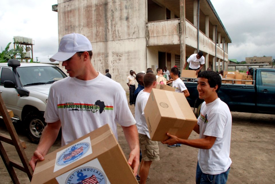 US Navy 080912-N-6544L-003 European region U.S. Navy soccer team member Chris Campos, left, passes boxes of Project Handclasp donations to Lt. Nick Whitney during a community relations event at the Bonadowito Public School in D