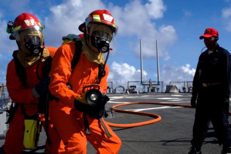 US Navy 080917-N-9123L-002 Seaman John Lennon guides Operations Specialist Seaman Eric Acy forward as Damage Control Training Team member Chief Damage Controlman Orlando Arao observes