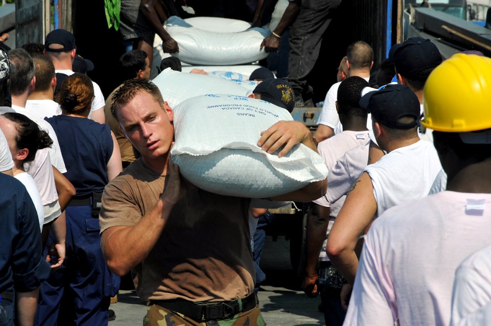 US Navy 080912-N-8907D-170 eaman Mark McCaw, assigned to the amphibious assault ship USS Kearsarge (LHD 3), carries food supplies to shore during disaster relief support to areas affected by recent hurricanes