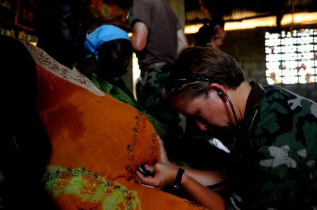 US Navy 080917-N-4515N-312 Lt. Candace D' Aurora listens for the heartbeat of a village woman's unborn child photo