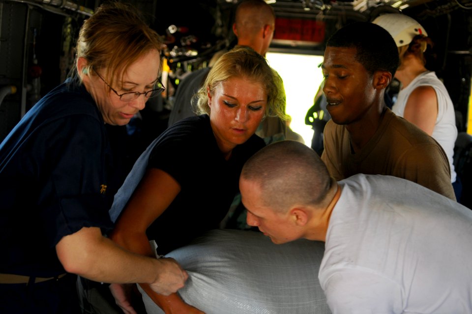 US Navy 080913-N-4515N-083 Service members embarked aboard the amphibious assault ship USS Kearsarge (LHD 3) load supplies onto helicopters for delivery to areas affected by recent hurricanes in Haiti