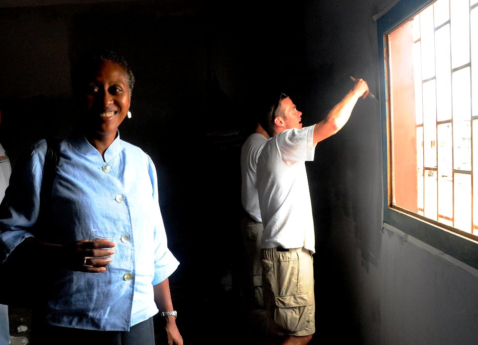 US Navy 080916-N-7526R-437 U.S. Ambassador to Gabon Eunice Reddick observes the progress members of the European region U.S. Navy soccer team have made painting a classroom during a community relations project