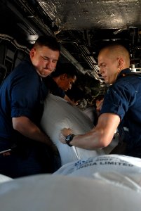 US Navy 080914-N-3595W-145 Service members embarked aboard the amphibious assault ship USS Kearsarge (LHD 3) load supplies onto a CH-53E Super Stallion helicopter for delivery to areas affected by recent hurricanes in Haiti photo