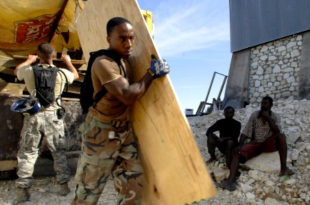 US Navy 080916-N-9620B-104 Builder 2nd Class Khristopher Woods, embarked aboard the amphibious assault ship USS Kearsarge (LHD 3), unloads construction materials for a four-hole burnout photo