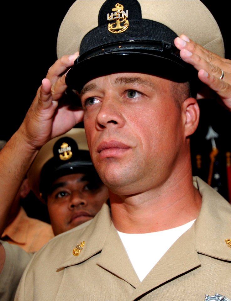 US Navy 080916-N-9758L-318 Chief Culinary Specialist James Reid receives his chief petty officer combination cover during a traditional Chief Pinning Ceremony