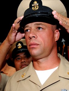 US Navy 080916-N-9758L-318 Chief Culinary Specialist James Reid receives his chief petty officer combination cover during a traditional Chief Pinning Ceremony