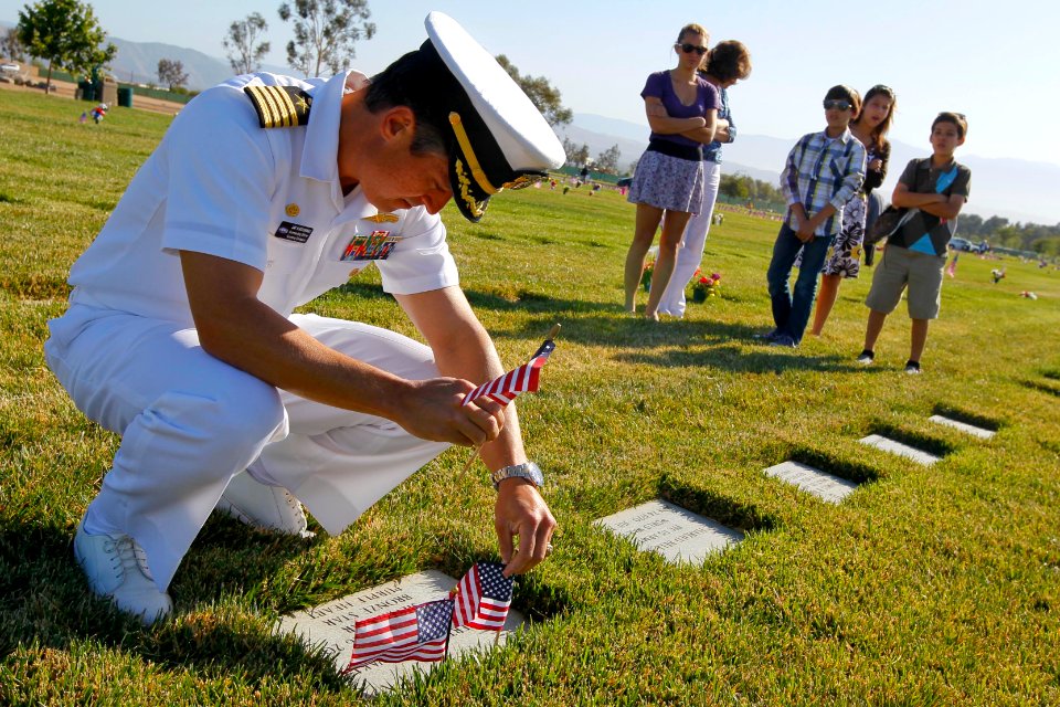 US Navy 110530-N-HW977-025 Capt. Jay Kadowaki places flags at the grave of his uncle, U.S. Army Spc. Robert Kadowaki, who served during the Vietnam
