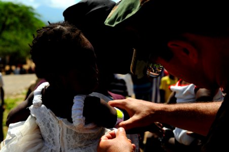 US Navy 080917-N-4515N-223 Lt. Hector Acevedo measures a child's arm circumference and height photo